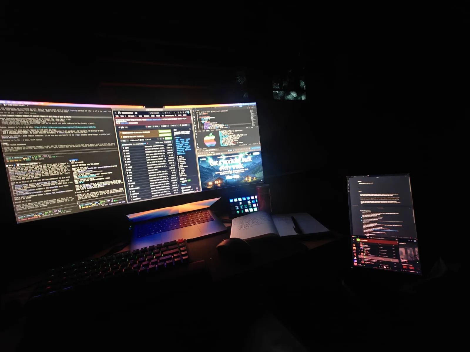 Secondary Dell monitor in portrait on a small laptop table on the floor, running Obsidian and Spotify.