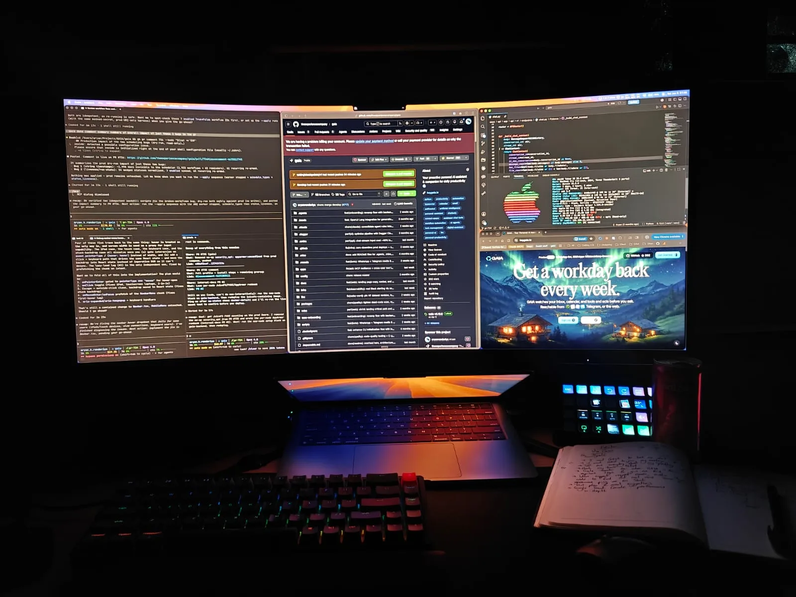 The current setup: a curved ultrawide monitor with three panes of work, a MacBook below it, a Keychron keyboard and a notebook.
