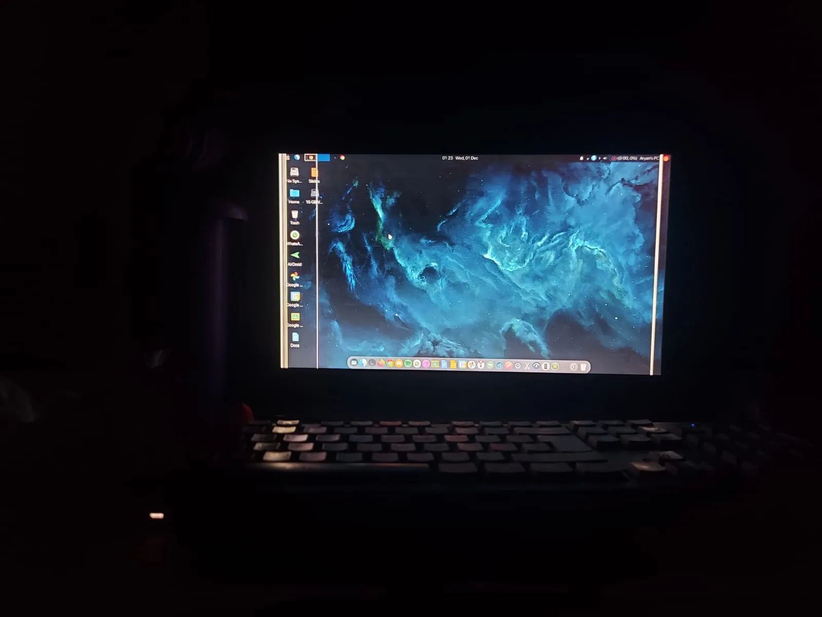 The Dell laptop running a heavily customised Linux desktop with a nebula wallpaper and a macOS-style dock.