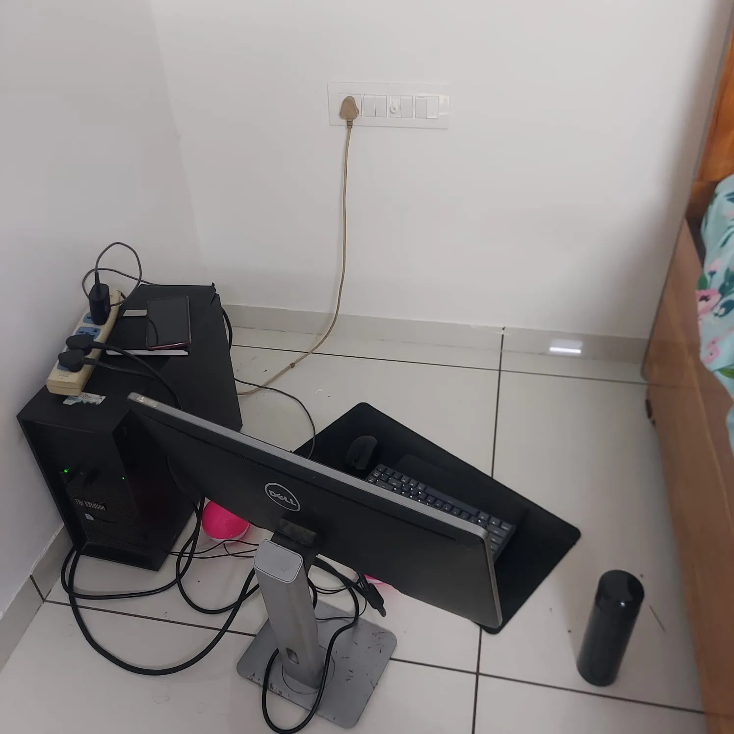 The ThinkStation tower and Dell monitor set up on the floor in a corner of the new flat, no table yet.