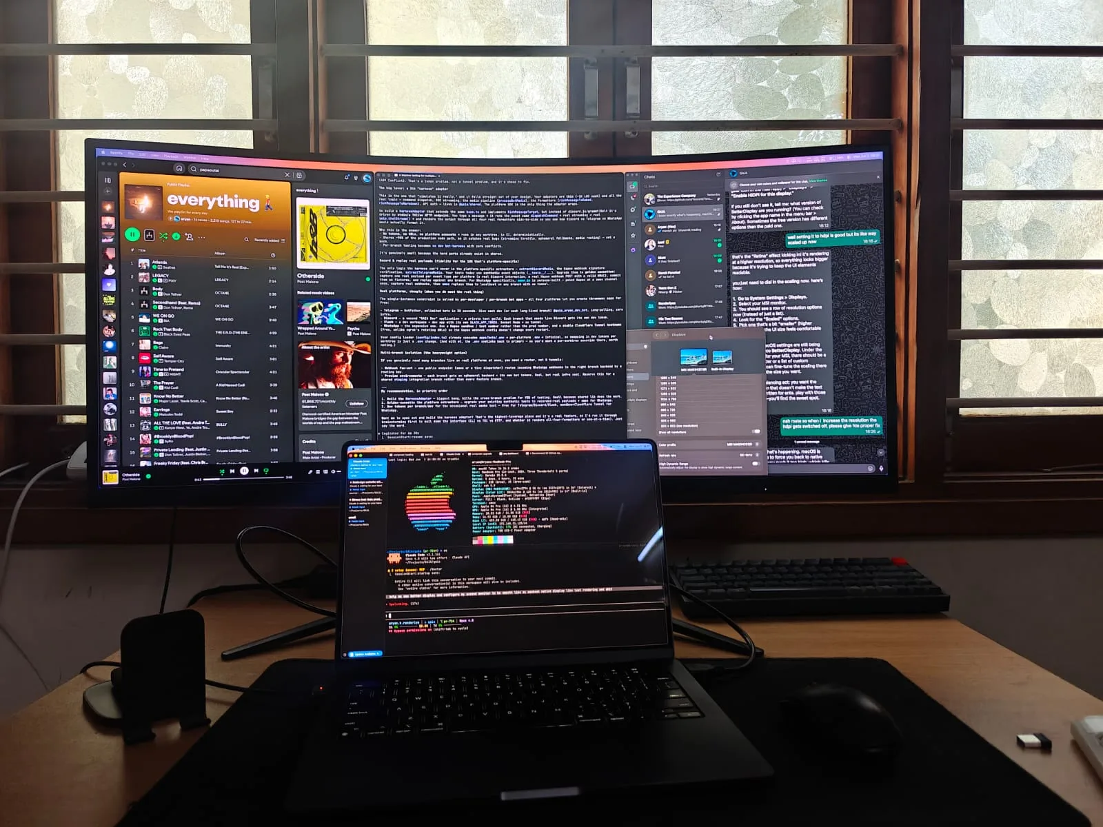 Setting up the curved MSI ultrawide monitor in daylight, with the MacBook showing system info and a BetterDisplay HDPI chat.
